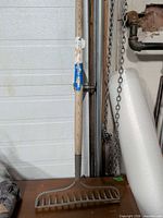 Full view of garden bow rake leaning against wall