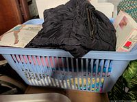 Basket overview with jacket, pantyhose boxes, assorted clothing