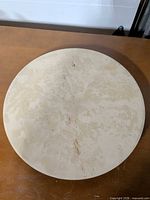 Top view of round ceramic baking stone showing surface wear