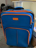 Front view showing blue fabric, orange trim, external pockets