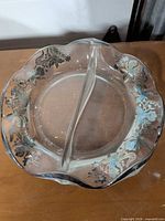 Top view of round clear glass divided dish showing scalloped rim and silver floral overlay