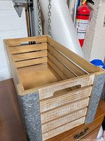 overview of wood crate showing slatted sides and galvanized-look corners