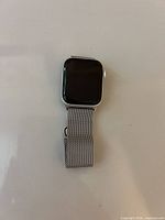 Front view of Apple Watch with screen off and band folded