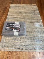Area rug and packaged door mat shown together