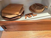 Rectangular board in front, stack of boards and bowl behind
