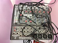 Top view of Behringer XENYX 1202FX mixer with connected cables visible across controls