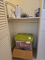 Closet shelf showing Brother sewing machine, cords and Singer accessory case, tote below