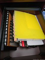 Drawer showing multiple disc-bound notebooks, assorted colours and rings
