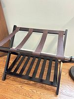 Luggage rack open showing wood frame, nylon straps, lower shelf