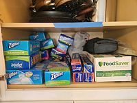 Shelf view showing Ziploc boxes, Reynolds Wrap rolls, FoodSaver sealer and bag combo pack