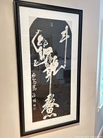 Full view of framed calligraphy artwork hanging on wall