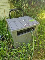 Front view of green plastic hose reel box with attached hose