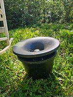 Full view of black plastic In2Care mosquito trap sitting on grass