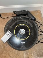 Top view of iRobot Roomba vacuum with dock and power cable
