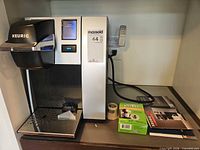 Front view of Keurig K150P brewer with accessories