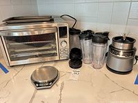 Front view of Gourmia toaster oven, Ninja blender base with cups and Salter scale