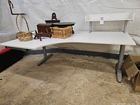 Front view of L-shaped desk with raised shelf attached, showing surface and leg design