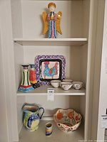 Full shelving view showing all ceramic pieces