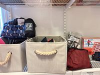 Overall lot with two canvas bins and travel accessories on shelf