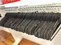 Row of black velvet hangers on chrome rod