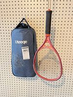 Grey Uteeqe carry bag and red tennis racket hanging