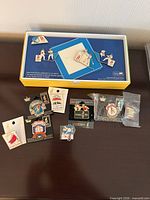 Boxed Beijing 2008 pin set with additional pins and watch on table