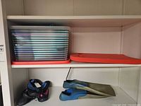 Shelf view with fins, water shoes, kickboard, storage bin