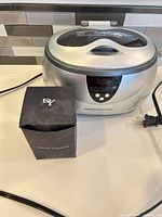 Magnasonic ultrasonic cleaner with power cord and David Yurman boxed set on counter