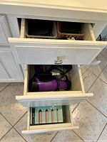 Three-drawer unit showing accessories, hair dryer, Amika box