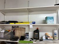 Shelf showing most items: wiper blade package, tissue box, wood pieces, oil bottle, paint can, tools