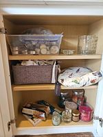 Entire cabinet view showing candles, holders, fabric items