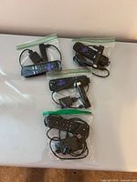 Four zipper bags each containing streaming stick, remote, cable, adapter