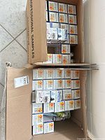 Two open cardboard cases filled with sealed NeilMed Sinus Rinse retail boxes