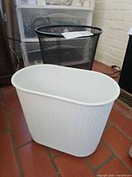 Front view showing black mesh and white plastic wastebaskets