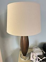 Full view of one lamp with shade, metal body and acrylic base