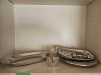 Tray, bowl, plate and spoon grouped on shelf