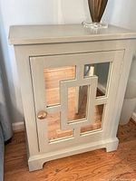 Front view of nightstand showing mirrored door and knob