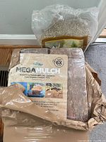 PlantBest MegaMulch bale in original plastic wrap with bag of sunflower hearts behind