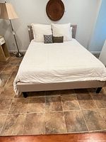 Full view of assembled queen bed with upholstered headboard and rails