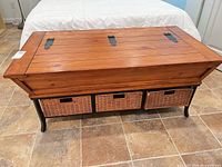Closed coffee table showing wood top, metal frame, three wicker drawers