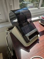 Front angled view of printer showing label slot and branding