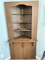 Front view of solid wood corner hutch showing shelves and cabinet doors