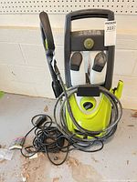 Front view showing full pressure washer, hose, wand, detergent bottles, power cord
