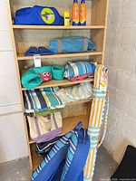 Full shelving view with umbrella, towels, fins, flotation gear, bag