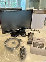 Front view of Tyler LED TV with accessories spread on surface