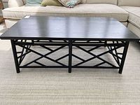 Front view of black wood cocktail table showing rectangular top and lattice base