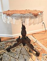 Full view of round pedestal side table with crochet cover on top