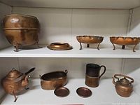 Full lot showing all nine copper pieces on shelves