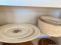 Stack of ribbed-rim dinner plates and covered stack of bowls