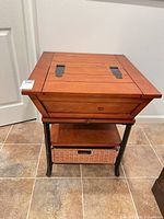 Front view of wood lift-top side table on metal legs with wicker basket